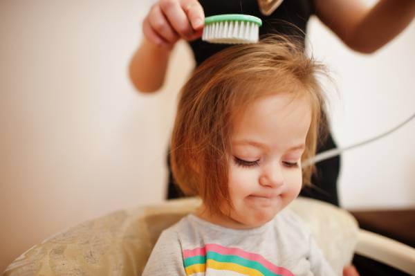 Mother combing their childs hair during their nightly routine before bed