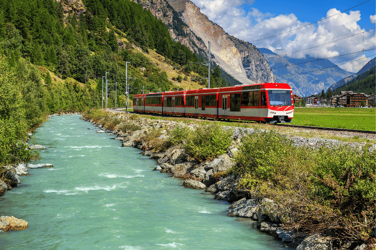 Red electric train in Switzerland Summer Travel Guide in Europe 2023