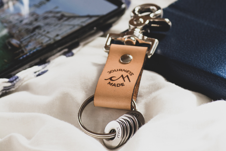 Natural leather travel keyring with engraved Italy token with a phone that shows a photo from a trip to Venice