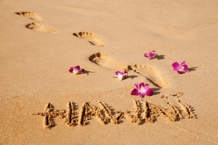 Hawaii written in the sand with footprints. Ultimate Destination for Beaches is Hawaii, USA.