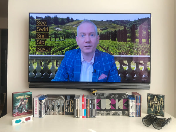 Scott Jeffrey teaching to see, swirl, sniff, sip, and savor wine on big screen TV.