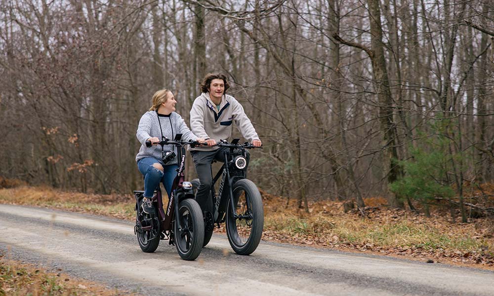 A couple is riding a Heybike ebike outside