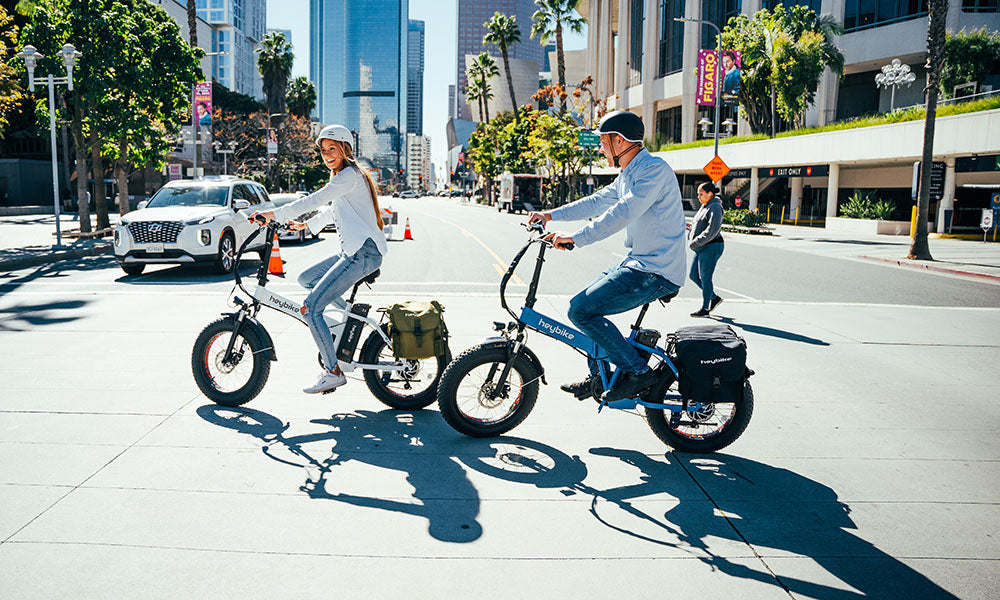 a couple are riding Mars folding e-bike on the city road