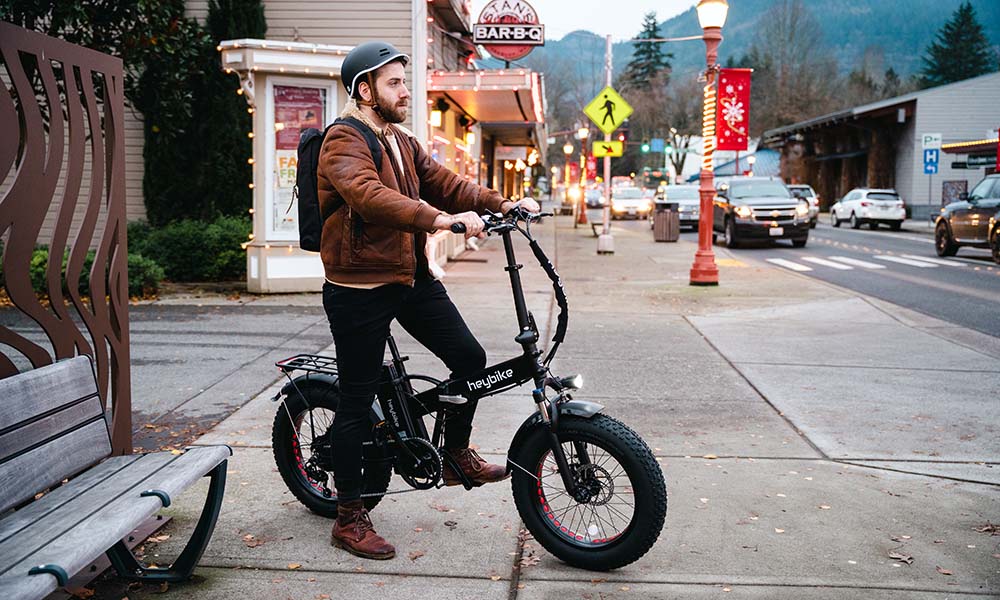 A man is riding a Mars folding fat tire e-bike on the road