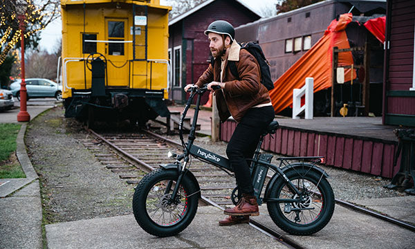 A man is riding a Mars folding e-bike for his commute