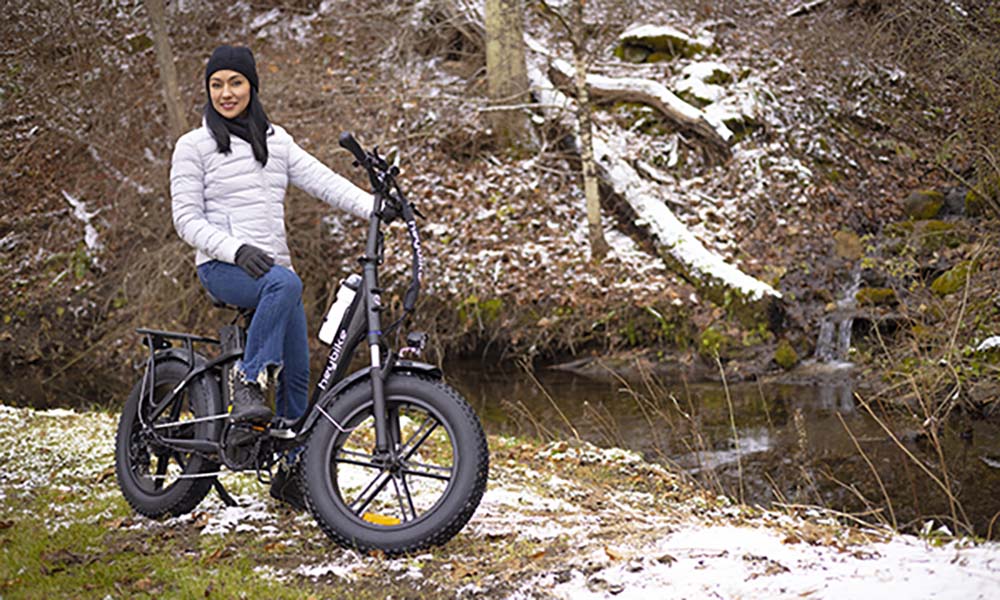 a female is riding step-thru ranger ebike by the river