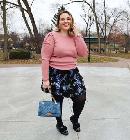 Plus size model in long sleeve pinktop with floral blue mid skirt