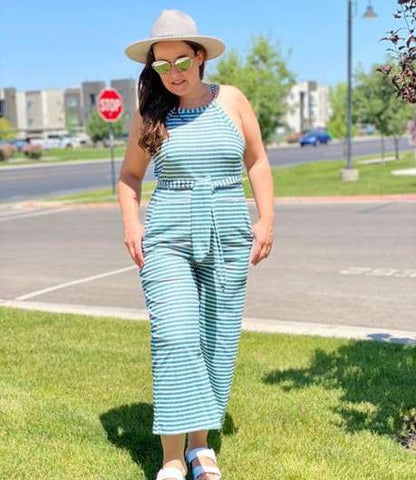 Plus size model in a light blue jumpsuit and hat