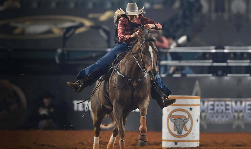 Cowgirl at a rodeo show tying up a horse - Arlington