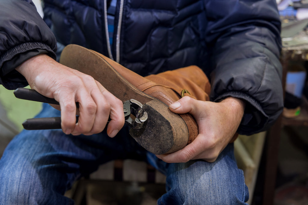 A man repairing a western boot