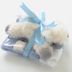 Blue Sheep Dreamzzz lovey inside a clear cellophane packet with a sheep doll on top, all tied together with a silky white ribbon