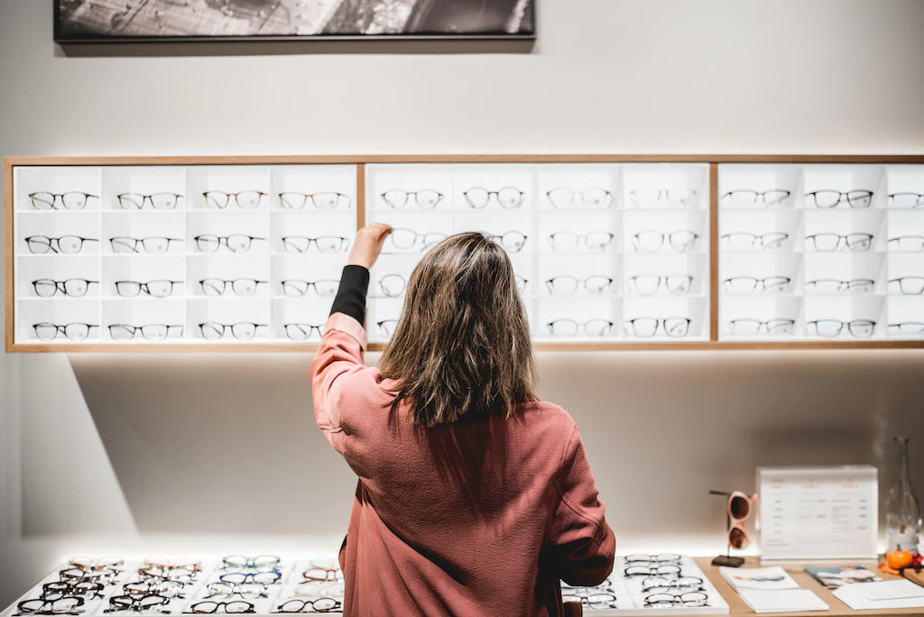 Female reaching a pair of glasses from huge selection of frames at JINS store