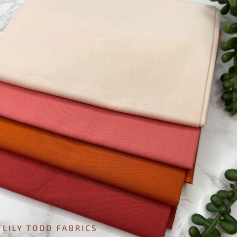 a picture of four fabrics in rust, orange, and pink colors.