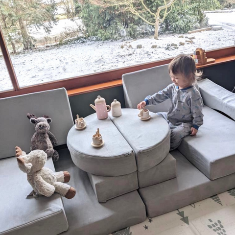 toddler girl makes a tea party with her barumba play couch