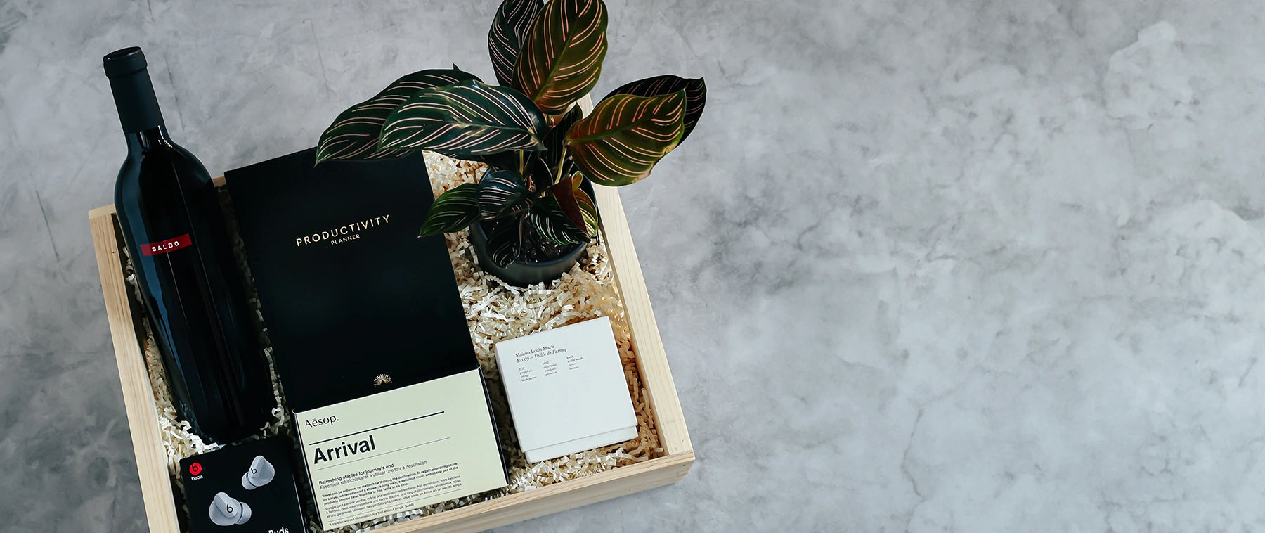 A chic custom gift box with a sleek plant and high end products.