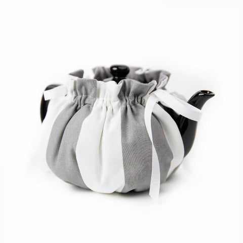 Black and gray tea cozy covering ceramic teapot.