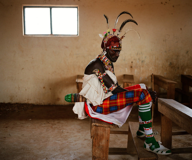 A Samburu moran shelters from the rains in a school room northern Kenya