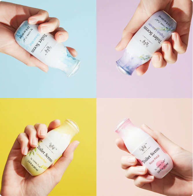 Hands holding the bottles of all four Whift spray scents: lemon drop, English lavender, rose petal, and ocean mist.
