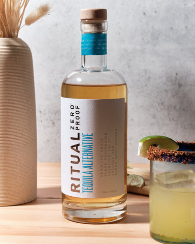 Bottle of Ritual Tequila Alternative next to Margarita made with Ritual