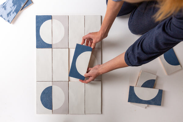 Designer creating patterns with decorated tiles