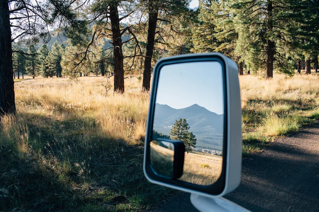 View of the mountains through the side mirror of a car