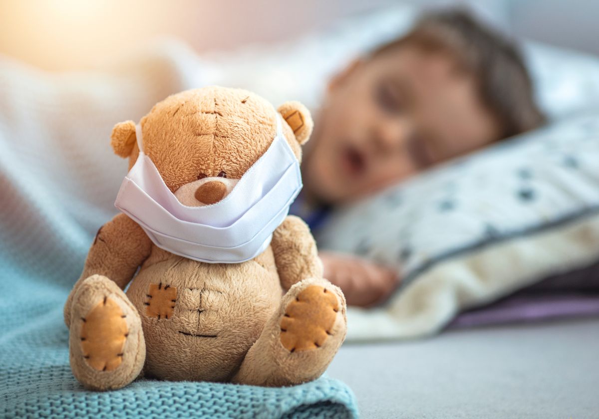 a sleeping child with a toy bear