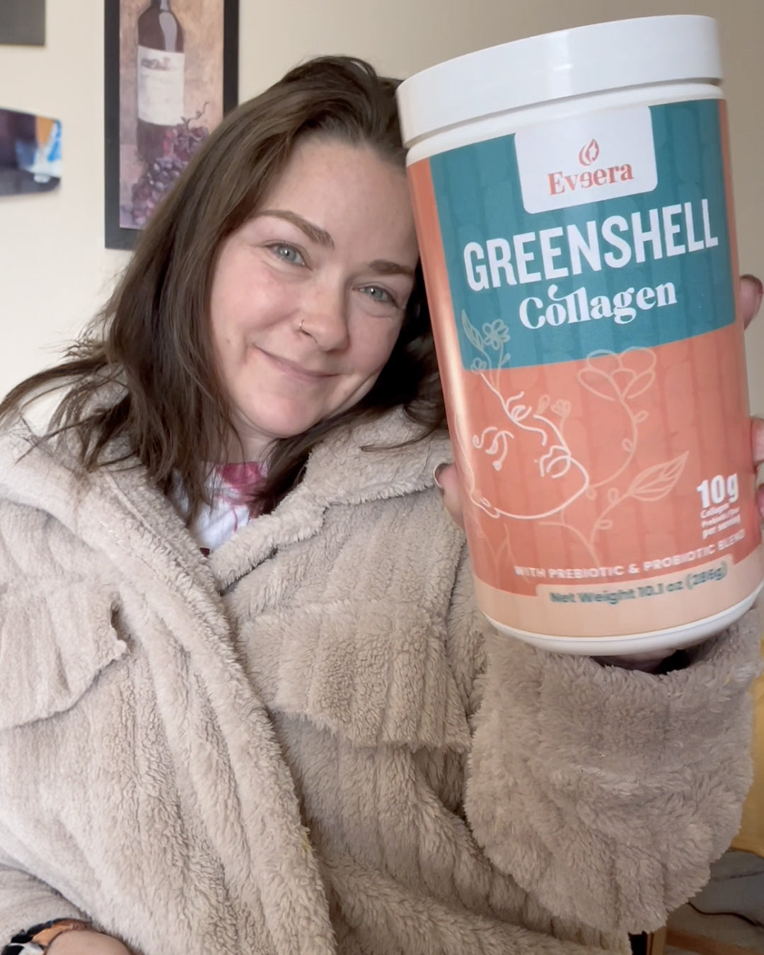 Woman holding a jar of Greenshell Collagen supplement.