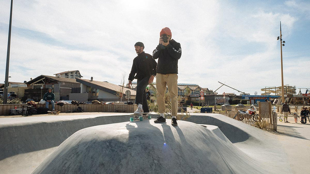 photographer standing in skate park taking photos of surfskate riders