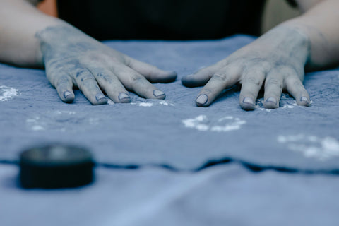 textil och händer med blå färg