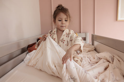 Child making their bed with the Evercool Kids Cooling Comforter and pillowcases in animal friends