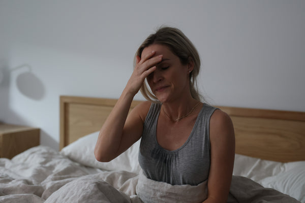 Woman in bed visibly frustrated