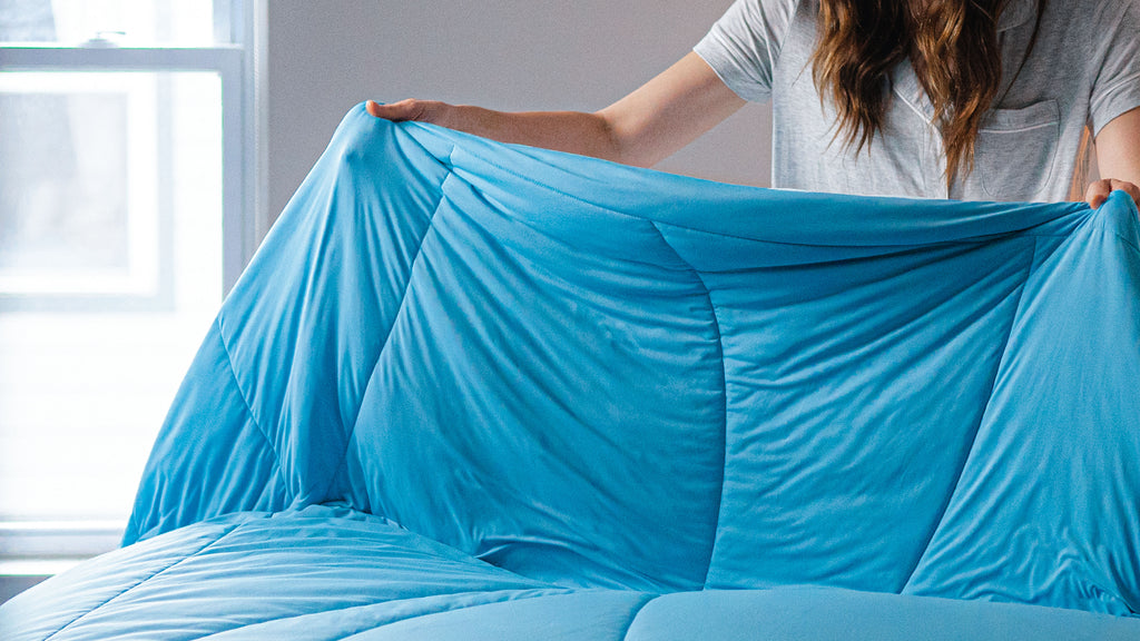 Person making their bed with the Evercool cooling comforter and cooling sheet set