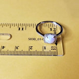 Sterling Silver Diamond Halo Opal October Birthstone Ring on a Ruler showing Ring Size