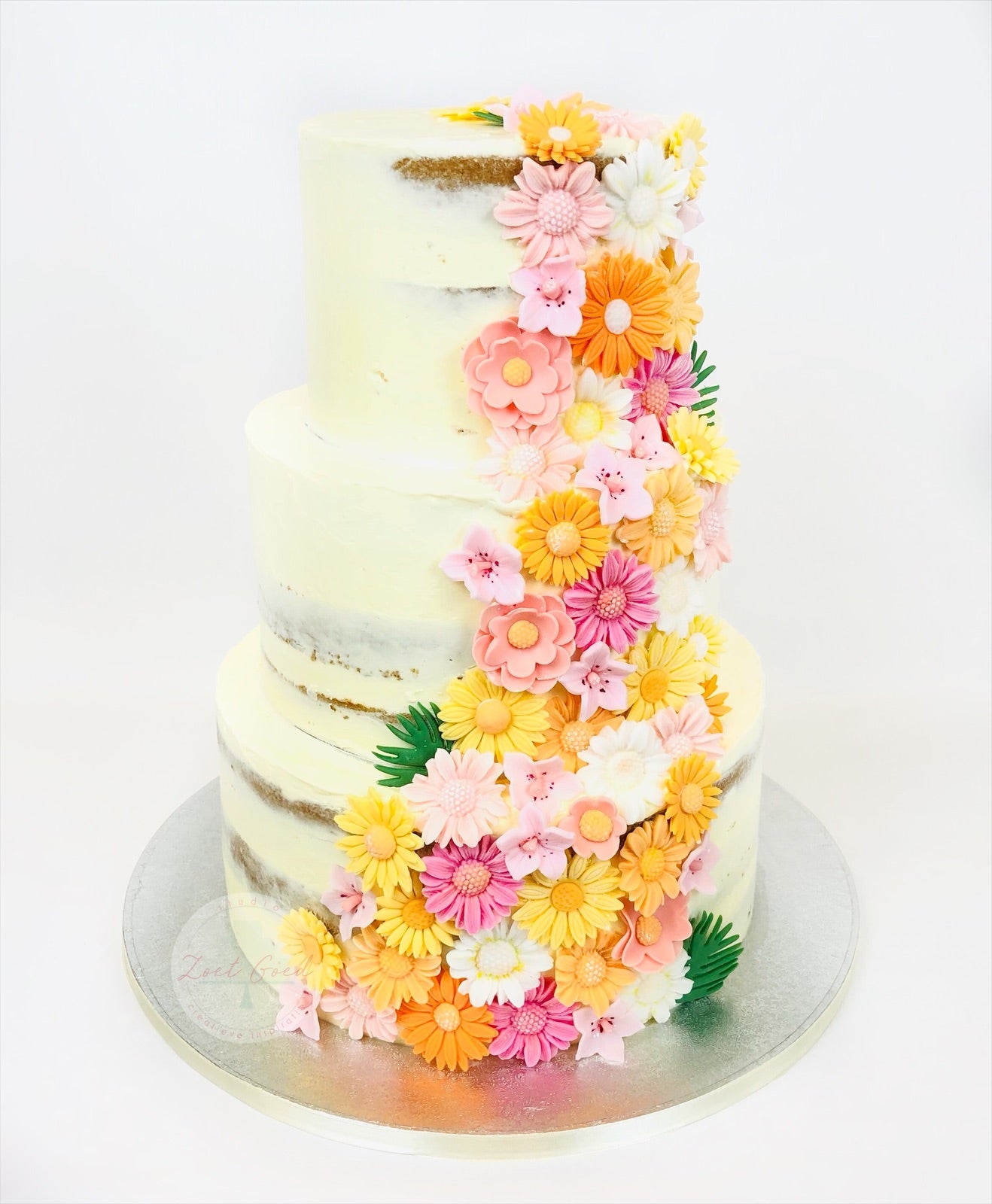 Botercreme bruidstaart met fondant bloemen tropisch