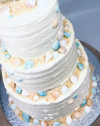 Botercreme taart bruidstaart wit pastel schelpen zee thema