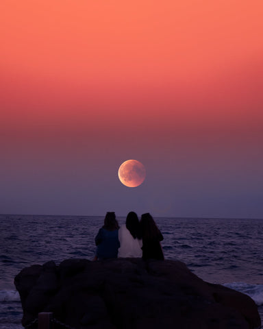 women watching the full moon