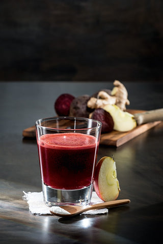 Beta purple juice. In the background you can see a wooden board with ginger.