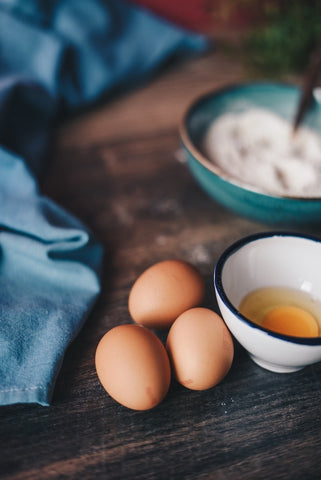 Eggs for the turmeric gugelhupf lie on a wooden board