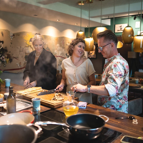 Kloster Kitchen Kochevent mit Roland Trettl und Influencern: Influencer stehen in der Küche nebeneinander und schneiden Zutaten