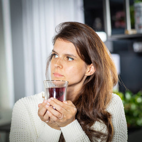 Woman holding tea glass with fruit tea in both hands