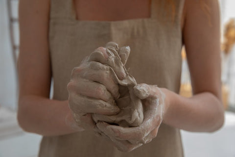Femme avec argile qui confectionne un vase