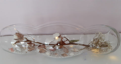 Vase allongé décorer avec du sable des coquillages et une guirlande lumineuse