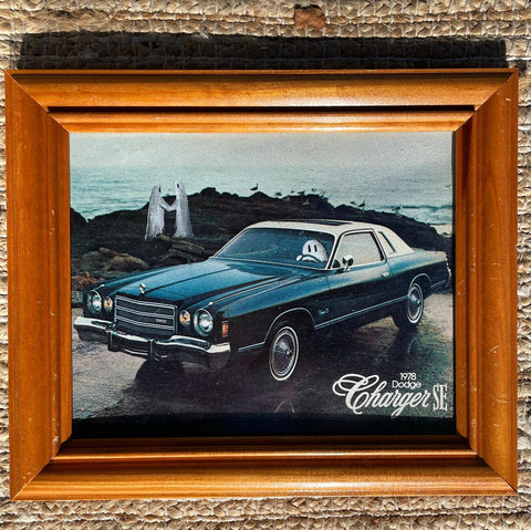 a painting by Ashley Miller. A vintage photo of a car driven by a ghost, while two ghosts standing on a cliff look out onto the water.