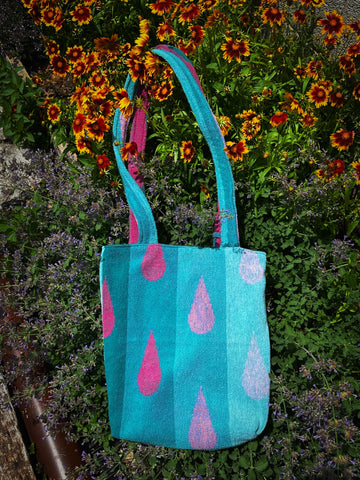 A terrycloth tote bag, with a teal, turquoise, and pink design. 