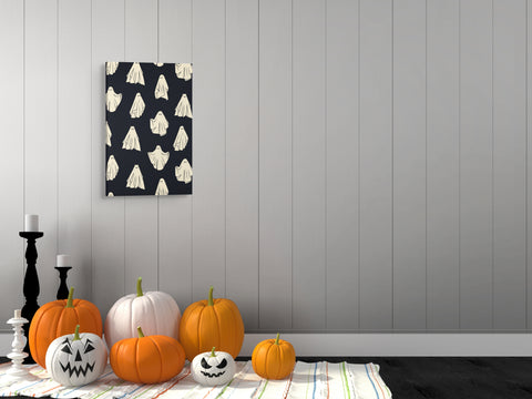 Lifestyle image of the vertical, 20x30” inch easy to hang canvas wall art hung above some Halloween decorations in a foyer.