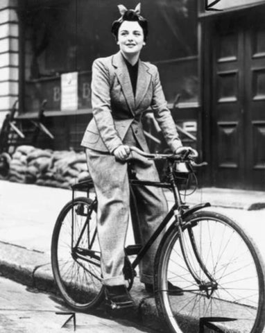 Femme en tailleur veste pantalon sur un vélo