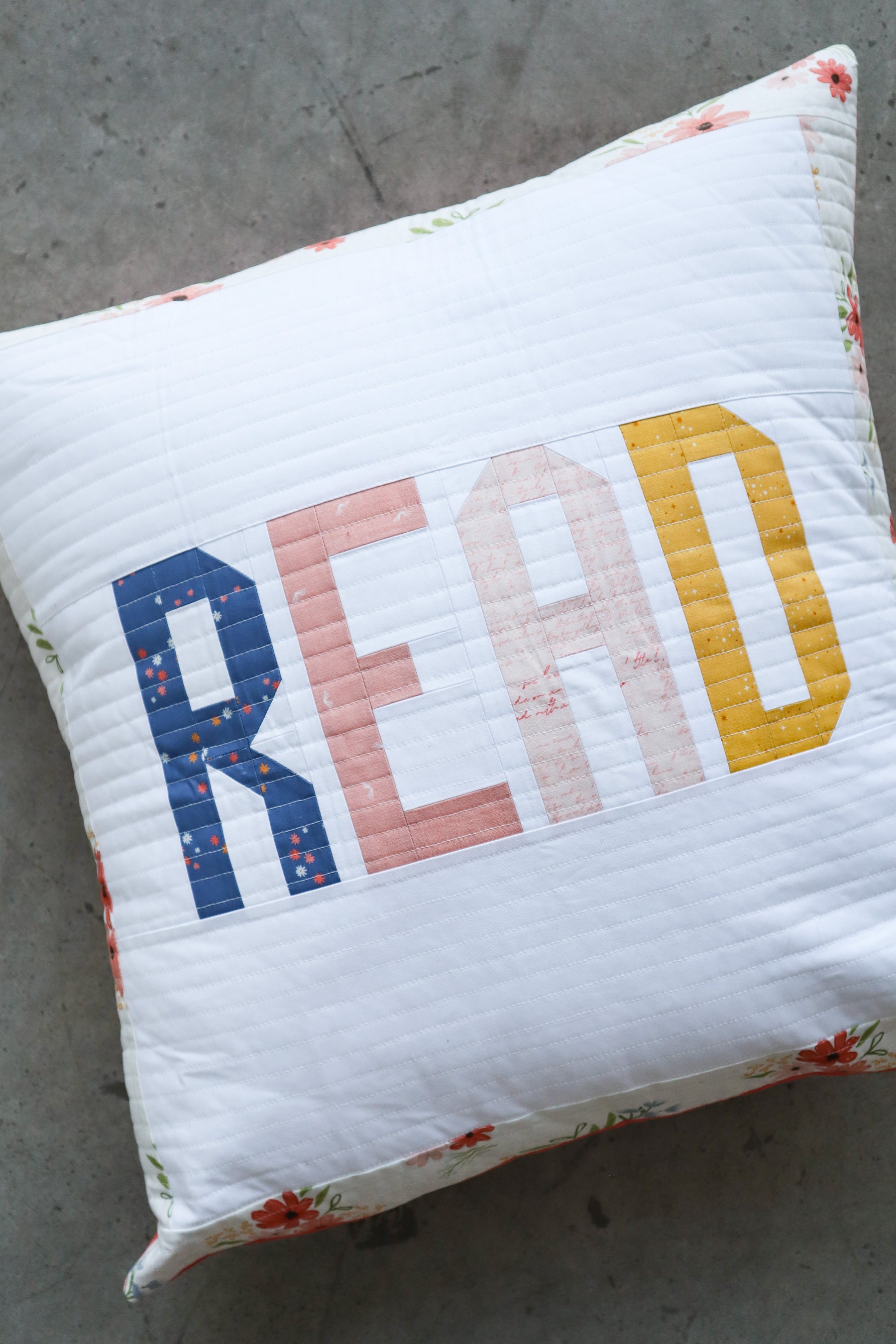 Scrappy quilted pillow tutorial – step-by-step guide for sewing a fabric letter pillow using Between the Pages fabric.