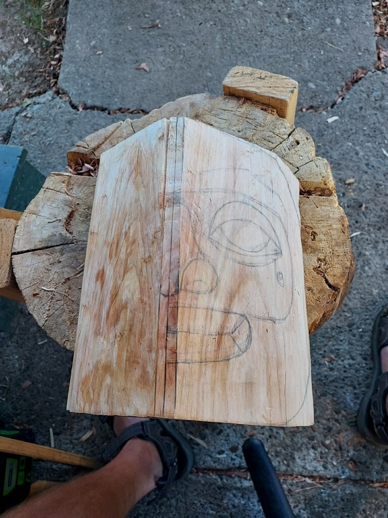 Fred Fulmer Native Artist drawing out the initial design of the mask on a block of alder wood
