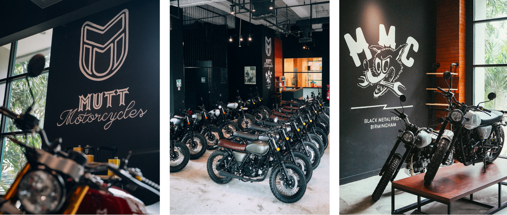 A motorcycle show room that is minimalist and industrial. Motorcycles are neatly lined up in a row.