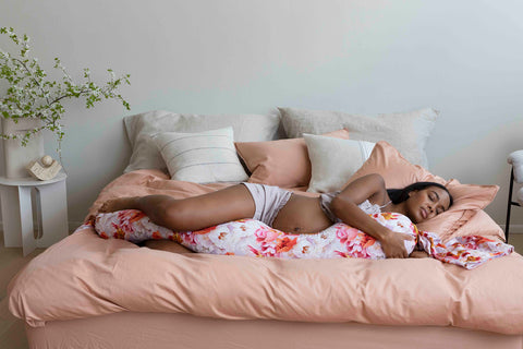 Woman sleeping with colorful pregnancy pillow